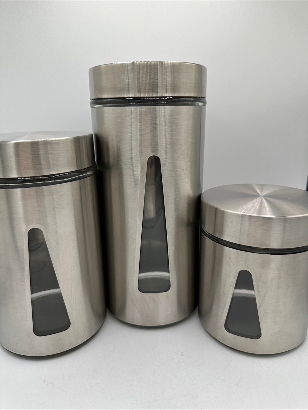 Three-piece steel and glass canister set with triangular viewing windows